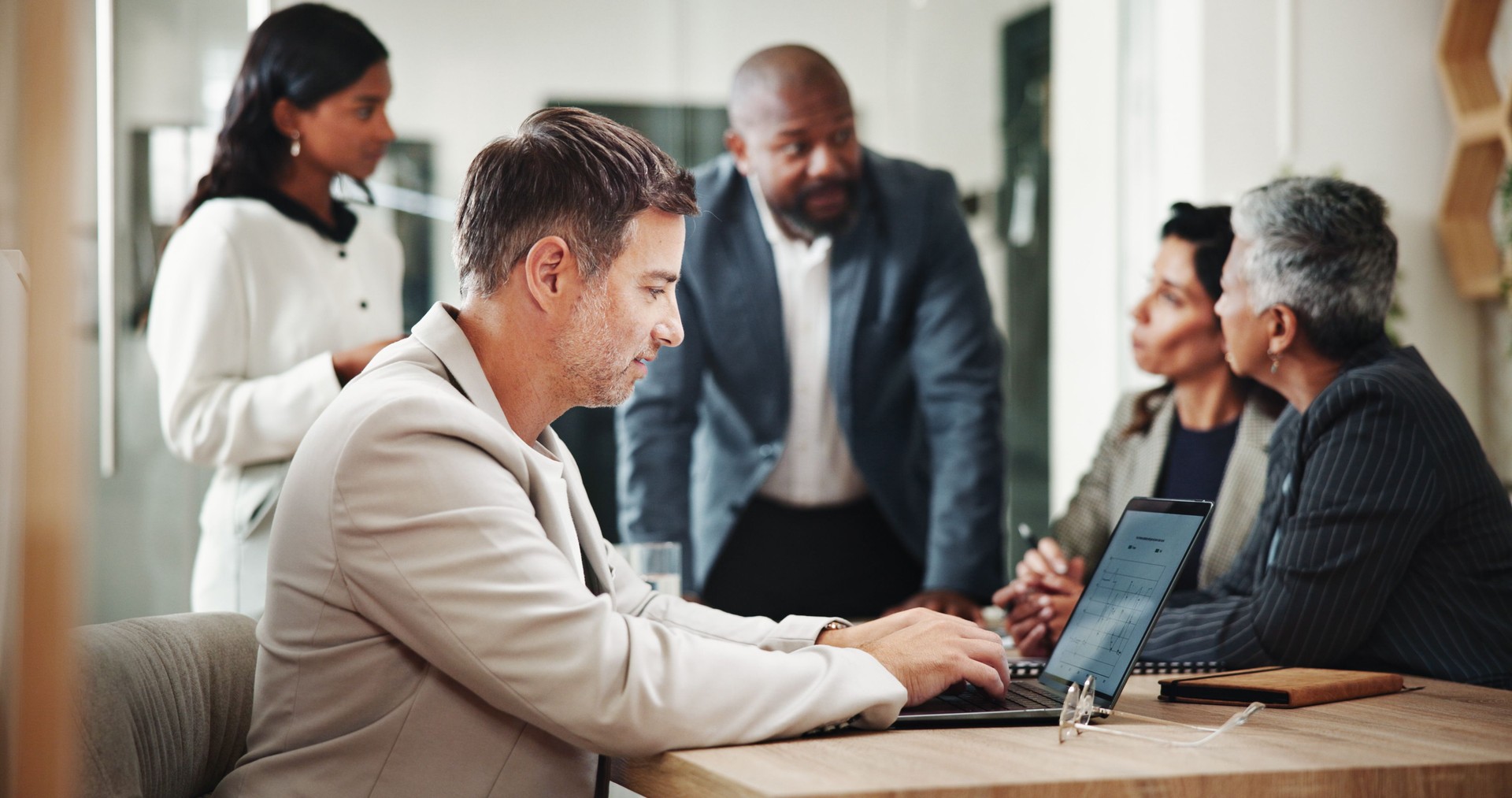 Office, business people and man with laptop for meeting, investment project and discussion. Teamwork, employees and financial advisor with research for audit, finance and feedback for report review